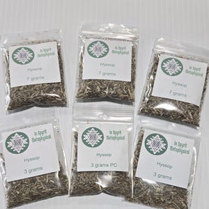Peut inclure: Six sachets transparents remplis d'herbes de hysope séchées. Chaque sachet porte une étiquette blanche avec le texte "In Spyrit Metaphysical", un motif géométrique et le mot "Hyssop". Certains contiennent 7 grammes, d'autres 3 grammes.