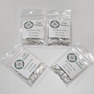 Four small, clear resealable bags filled with white Scolecite chip stones. Two bags are labeled "Scolecite Chip 10 Grams 50 Carats" and two are labeled "Scolecite Chip 20 Grams 100 Carats," all featuring the InSpyrit Metaphysical logo