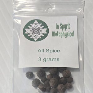 A small, clear plastic bag of whole Allspice berries from InSpryitMetaphysical. The white label features a green geometric logo at the top with the text "InSpryit Metaphysical," followed by "All Spice" and "3 grams." The dark brown, round dried berries are clustered at the bottom of the bag.