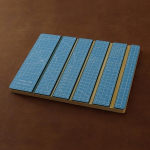 Könnte beinhalten: Eine blaue Schneidematte mit einem Rastermuster und Maßangaben. Die Matte ist 30 x 22 cm groß und besteht aus mehreren Abschnitten. Der Text "Cutting Mat Size: 30x22cm" ist sichtbar.