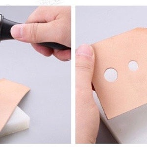 May include: A person using a mallet and punch tool to create holes in a piece of tan leather. The leather is placed on a white surface. The image shows the process of leather crafting, with various sized holes punched into the leather.