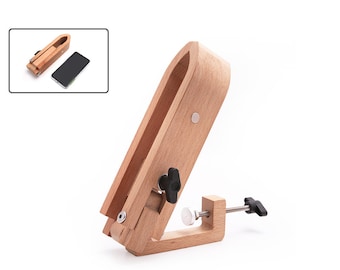 May include: A wooden leathercraft stitching pony with a clamp base. The light brown pony has a curved top and adjustable knobs. An inset shows a smaller leathercraft tool and a smartphone.