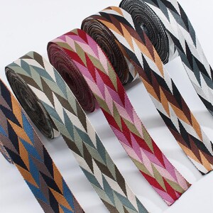 May include: Several rolls of patterned woven ribbon in a variety of colours. The diamond pattern repeats across the ribbons, with colours including blue, orange, green, pink, and brown. Ideal for craft and sewing projects.
