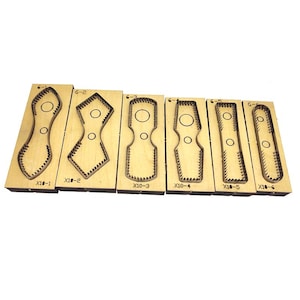 May include: Six wooden die-cut tools with metal cutting edges, each mounted on a rectangular wooden base. The tools feature different shapes and are labelled with numbers and letters. They are arranged in a row against a white background, ideal for crafting.
