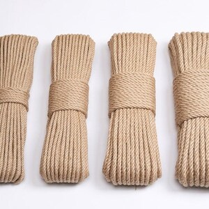 May include: Four bundles of natural-colored rope, tightly wound and secured with matching rope. The bundles are arranged side by side against a white background. The rope appears to be made of a coarse, fibrous material.