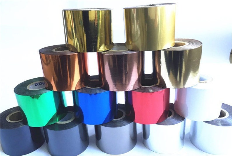 May include: A collection of foil rolls in a range of colours, such as gold, copper, blue, and red. The rolls are tightly wound and have a shiny, metallic finish. The image is well-lit, highlighting the different colours and textures of the foil.