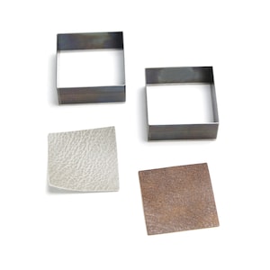 May include: Four square metal forms and two square leather pieces are displayed on a white background. Two metal squares are open frames. One leather square is light gray with a textured surface, and the other is brown.