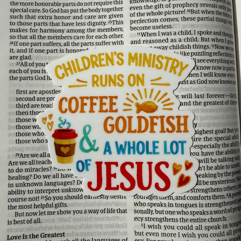 May include: A sticker with the text "CHILDREN'S MINISTRY RUNS ON COFFEE & GOLDFISH & A WHOLE LOT OF JESUS." The sticker features a coffee cup, a goldfish, and hearts.