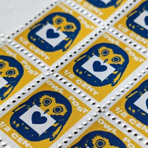 May include: A sheet of yellow and blue postage stamps featuring an owl design. Each stamp depicts an owl holding a white envelope with a blue heart. The text "OWL POST" and "1/2 CENT" is printed on each stamp.