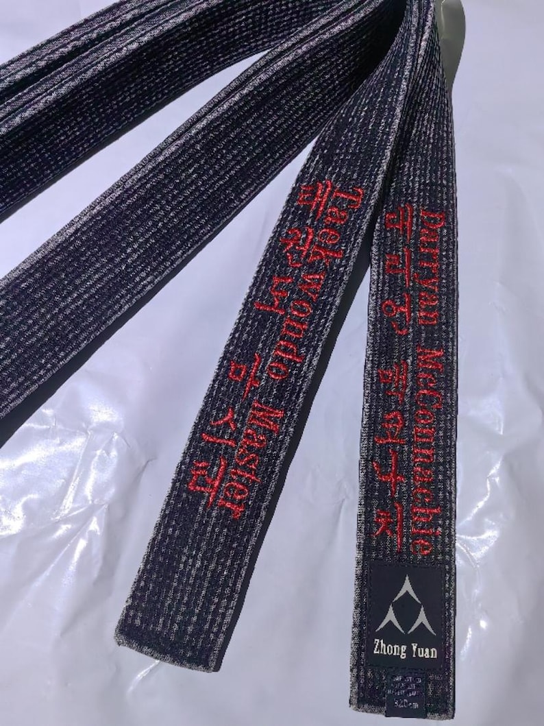 Pu&ograve; includere: Cintura nera di arti marziali con testo ricamato in rosso che recita "Taekwondo Master" e "Zhong Yuan".