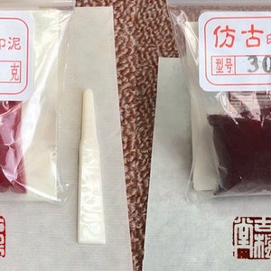 May include: Two small plastic bags containing red and burgundy colored paint with a small wooden applicator. The bags are labeled with the text "末  刷" and "30  克" and "仿古" and "30  克".