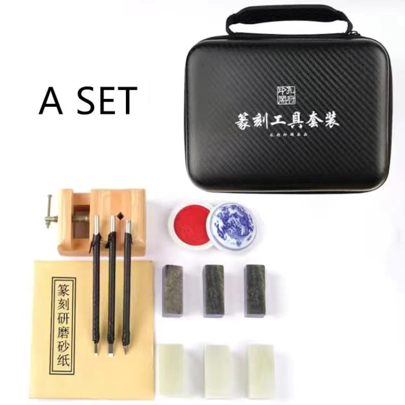 May include: A set of carving tools in a black carrying case with a Chinese inscription that reads "Carving Tools Set". The set includes three carving tools, a wooden tool holder, a red ink pad, a blue and white porcelain dish, and six sharpening stones.