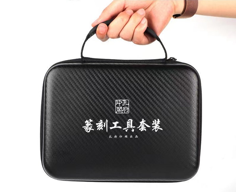 May include: A black carbon fiber carrying case with a white zipper and a white label that says "篆刻工具套装" and "孔府印社".