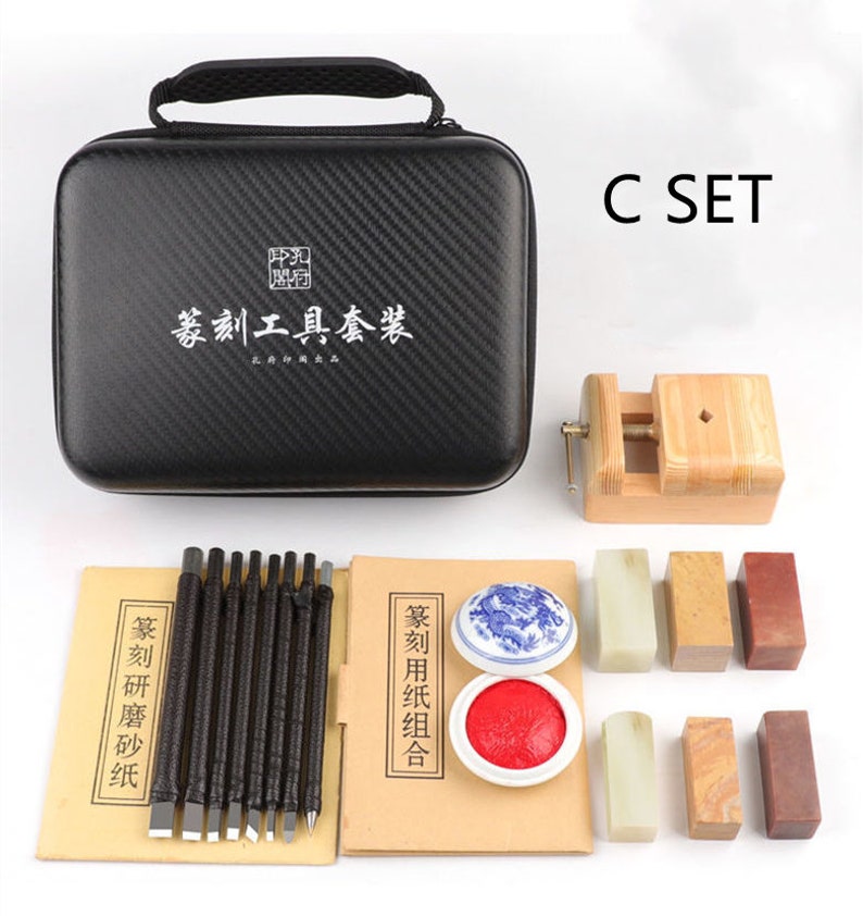 May include: A black carrying case with a Chinese inscription, a set of carving tools, a wooden clamp, and a set of red and green ink pads and stamps. The set is labeled "C SET".