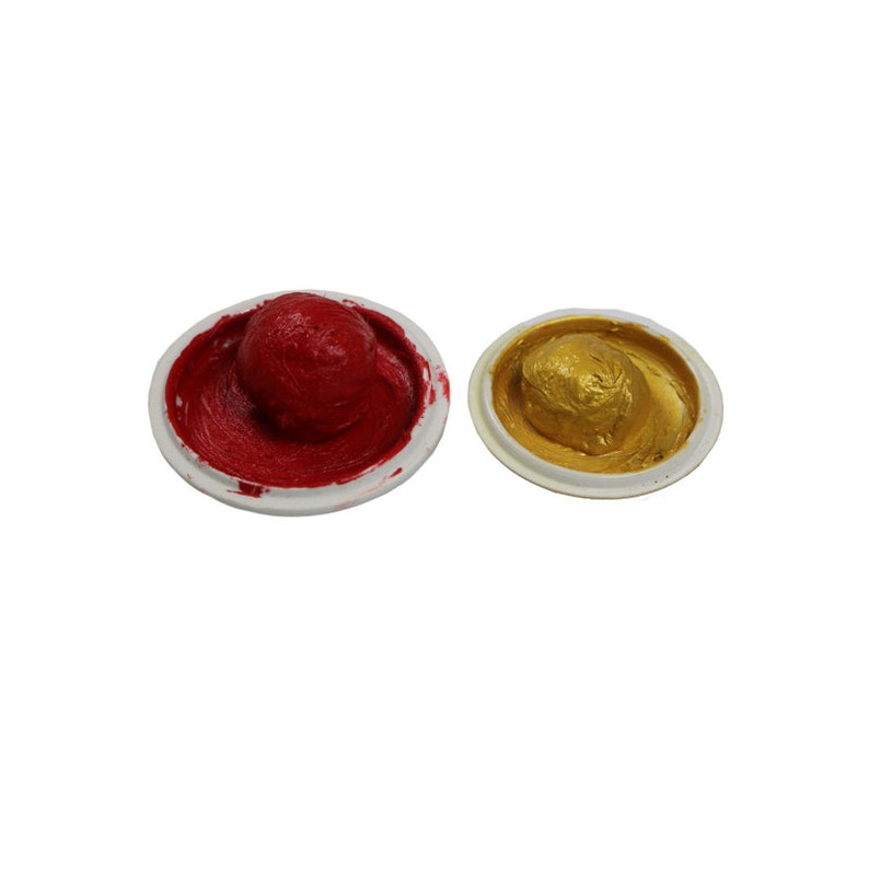 May include: Two ink pads, one red and one gold, in their containers. The ink pads are round and have a slightly domed shape.