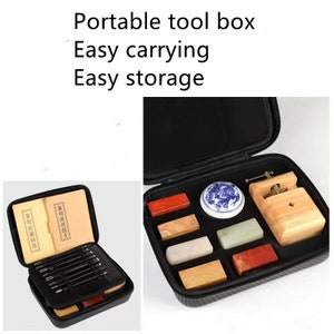 May include: A black carrying case with a zippered closure, containing a set of tools for carving and stamping. The tools include a small wooden press, a small white ceramic bowl, and several rectangular blocks of different colored stones. The case is labeled "Portable tool box - Easy carrying Easy storage".