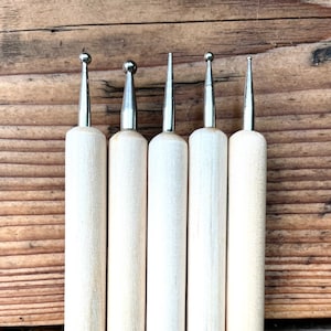 Könnte beinhalten: Fünf Werkzeuge mit Holzgriffen und verschiedenen Metallspitzen. Die Spitzen sind rund, spitz und flach.