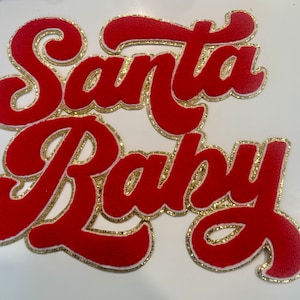 May include: Red felt applique with gold glitter trim that reads "Santa Baby".