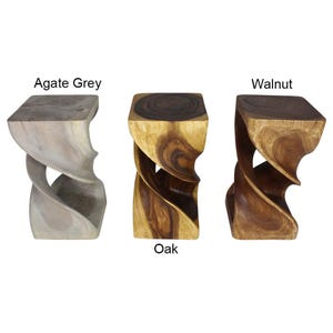 May include: Three wooden stools in different wood finishes: Agate Grey, Oak, and Walnut. The stools are carved in a twisted, spiral design.