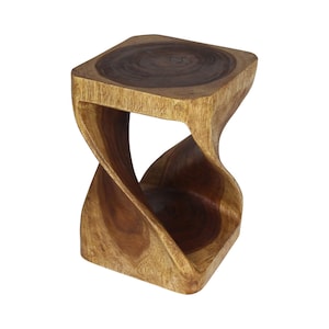 May include: A square wooden stool featuring a twisted hourglass-shaped base. The top surface and the base are crafted from dark brown wood, while the central twisted support displays a lighter, natural wood grain with visible texture and patterns.