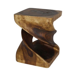 May include: A solid wood stool featuring a natural brown finish with visible grain patterns. The stool has a square top and base connected by a central twisted, hourglass-shaped support structure, creating an open, sculptural silhouette.