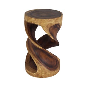 May include: A cylindrical wooden stool featuring a natural grain pattern with dark brown and light tan tones. The structure is carved into a continuous, spiraling, twisted shape that connects the circular top surface to the circular base.
