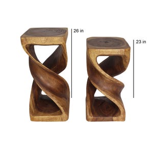 May include: Two wooden stools with a twisted design. The taller stool is 26 inches high and the shorter stool is 23 inches high.