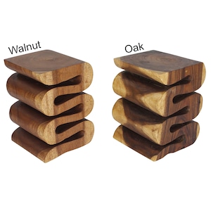 May include: Two wooden stools with a wavy design. The stool on the left is labeled "Walnut" and the stool on the right is labeled "Oak".