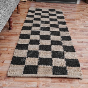 Puede incluir: Una alfombra de yute a cuadros en blanco y negro. La alfombra est&aacute; hecha de fibras naturales y tiene un aspecto r&uacute;stico. Es perfecta para a&ntilde;adir un toque de estilo a cualquier habitaci&oacute;n.