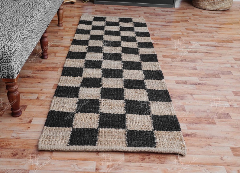 Puede incluir: Una alfombra de yute a cuadros en blanco y negro. La alfombra est&aacute; hecha de fibras naturales y tiene un aspecto r&uacute;stico. Es perfecta para a&ntilde;adir un toque de estilo a cualquier habitaci&oacute;n.