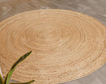 May include: A round, natural fiber rug with a woven texture. The rug is light brown in color and has a circular pattern.