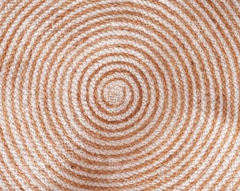 May include: A round, woven rug with a spiral pattern in beige and white.