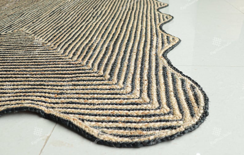 May include: A black and natural jute rug with a wavy edge and a chevron pattern.