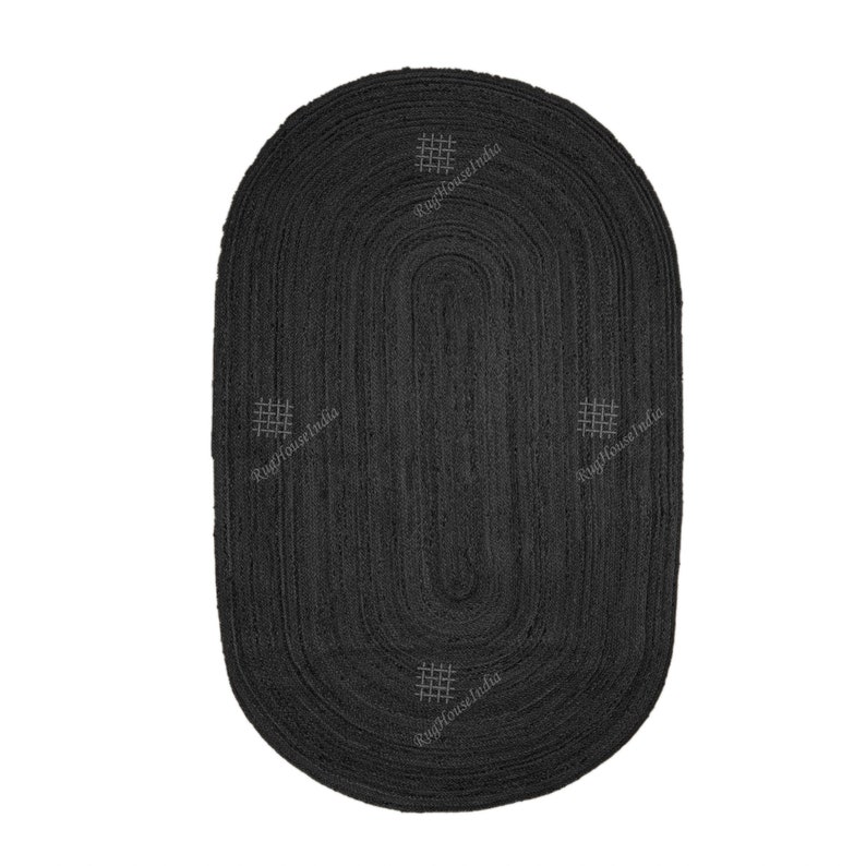 May include: An oval-shaped black braided rug featuring a textured surface with concentric circular patterns. Four small, light-colored grid-like square motifs are evenly spaced around the center. The text RugHouseIndia is visible near each motif.