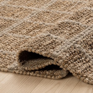 May include: A woven area rug featuring a textured, chunky loop pile construction in a natural tan and beige color palette. The rug displays a repeating grid pattern formed by raised, thicker fibers, with one corner folded over to reveal the underside.