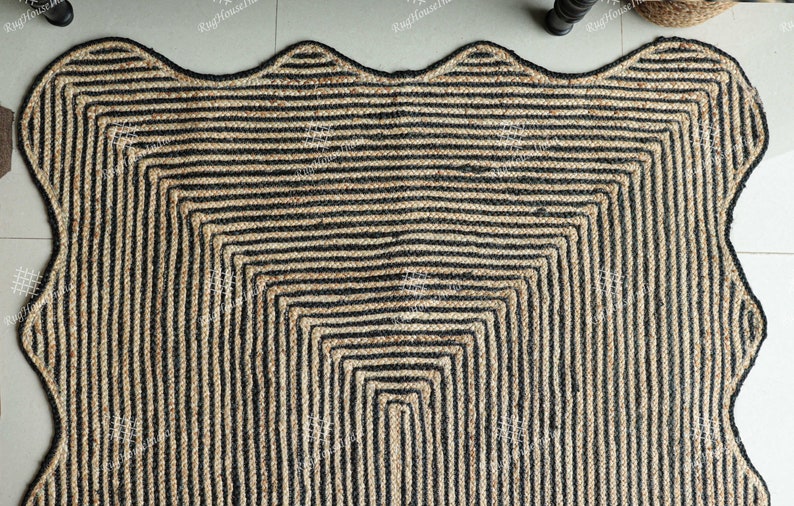 May include: A black and natural jute rug with a wavy edge and a geometric pattern of black stripes. The rug is made of natural fibers and has a rustic look.