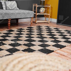 Puede incluir: Una alfombra de yute natural y negro con un patr&oacute;n de cuadros. La alfombra est&aacute; hecha de fibras naturales y tiene un aspecto r&uacute;stico.