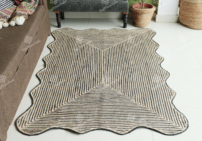 May include: A black and natural jute rug with a wavy edge and a geometric pattern. The rug is made of natural fibers and has a rustic look.