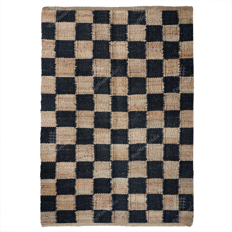 Puede incluir: Una alfombra de yute a cuadros negros y tostados. La alfombra est&aacute; hecha de fibras naturales y tiene un aspecto r&uacute;stico.