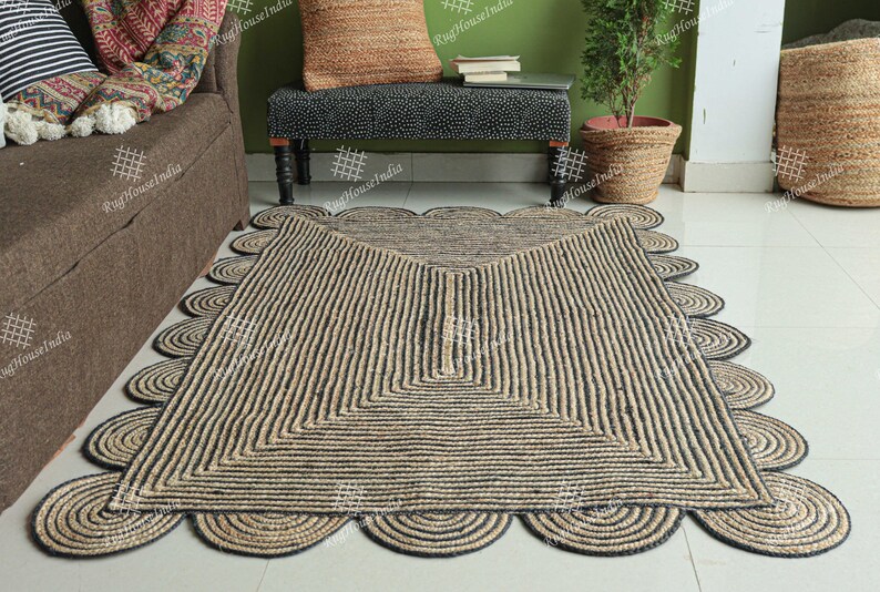 May include: A black and natural jute rug with a geometric pattern and scalloped edges. The rug is made of natural fibers and has a rustic look.