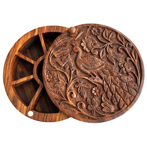 May include: A round wooden box with a hand-carved peacock design on the lid. The box has six compartments inside and is 9 inches in diameter.