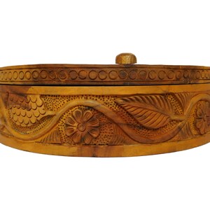 May include: A wooden box with a carved floral design. The box is brown and has a lid.