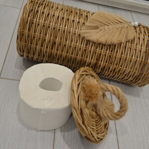 Puede incluir: Una cesta de mimbre con tapa y borla. La cesta est&aacute; vac&iacute;a y la tapa est&aacute; abierta. La cesta est&aacute; sobre un suelo de madera clara.
