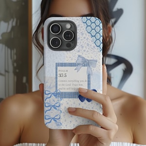 May include: A light blue and white floral phone case with a bow design and the text "PSALM 37:5". The case has a camera cutout and a decorative blue pattern at the top.