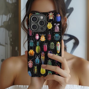 May include: A black phone case with a colorful pattern of beetles and bugs. The case has a camera lens cutout and a black background.