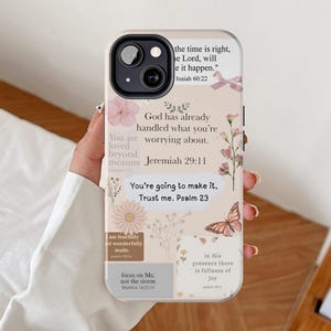 Puede incluir: Una funda de teléfono beige con un diseño floral y de mariposas. La funda presenta citas inspiradoras y versículos bíblicos, incluyendo "Dios ya ha manejado aquello por lo que te preocupas." y "Vas a lograrlo, confía en mí. Salmo 23."