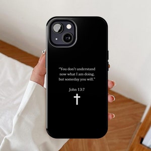 May include: Black phone case with a white quote from the Bible, "You don't understand now what I am doing, but someday you will." John 13:7, and a white cross.
