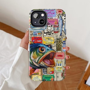 Può includere: Custodia per telefono colorata con un collage di etichette vintage di scatole di sardine e sgombri, con una grande e vivace illustrazione di pesce. Il design include testo in più lingue e una varietà di colori.