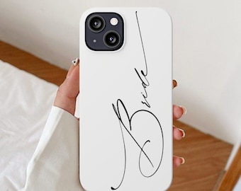 May include: White iPhone case with a black cursive script that says "Bride".