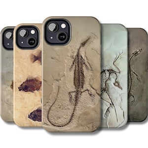 May include: A collection of phone cases featuring fossil designs. The cases display images of fish, a lizard, and other prehistoric creatures. The cases have a neutral color palette with shades of brown, beige, and gray.